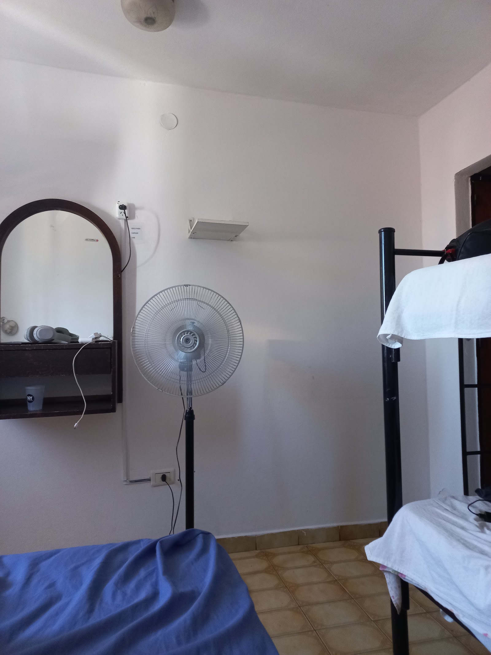 Habitación del hotel con ventilador de pie y camas